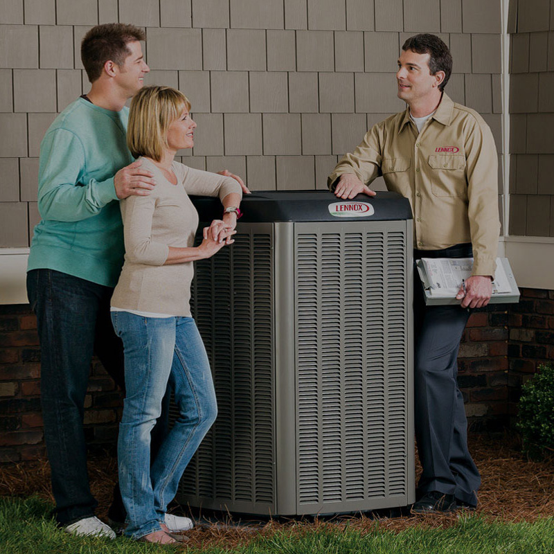 Lennox serviceman discussing Lennox A/C unit with man and woman outside of house