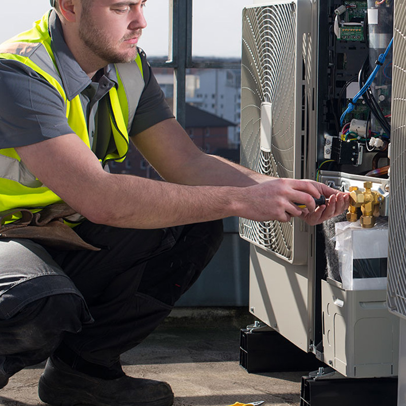 HVAC repairman servicing A/C unit